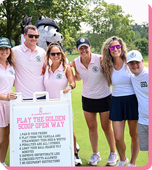 Group of five smiling people and a mascot posing outdoors on a golf course around a sign with golf rules.