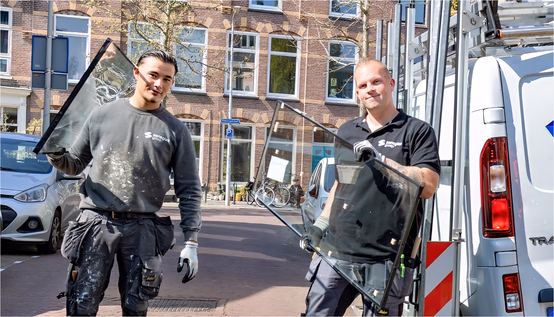 Twee glazenwassers met ruiten en bedrijfsbus in Nederlandse straat
