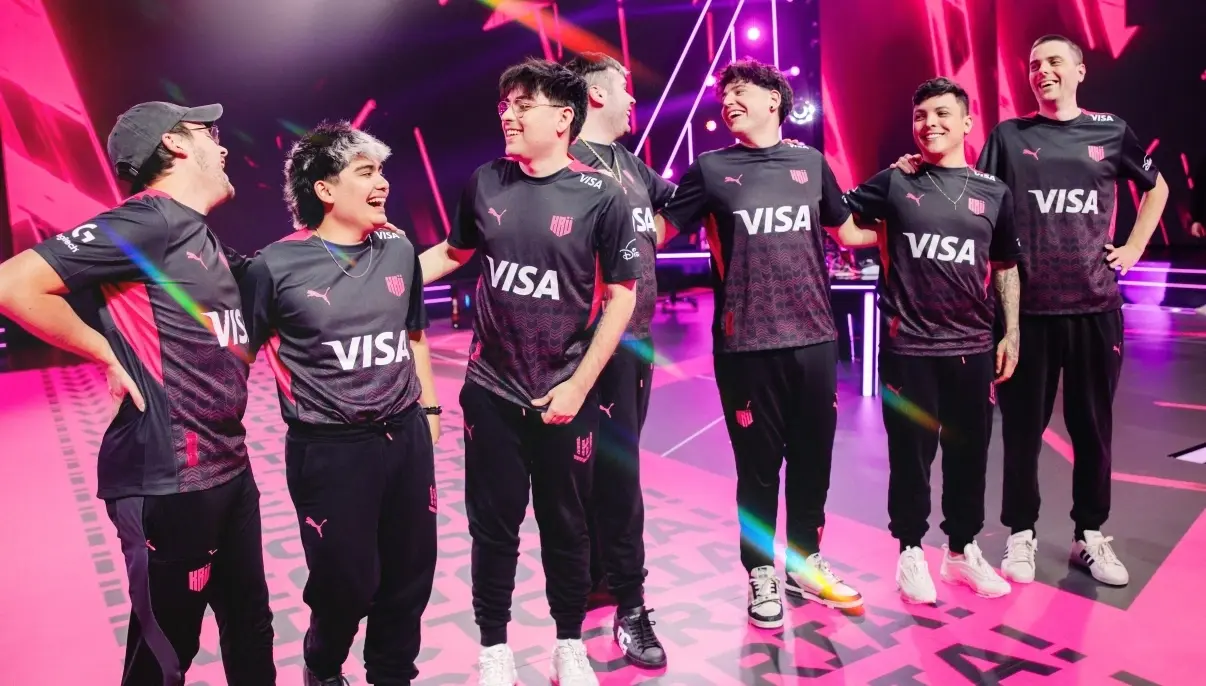 Esports players from KRU Esports in black-purple VISA jerseys smiling together on brightly lit stage