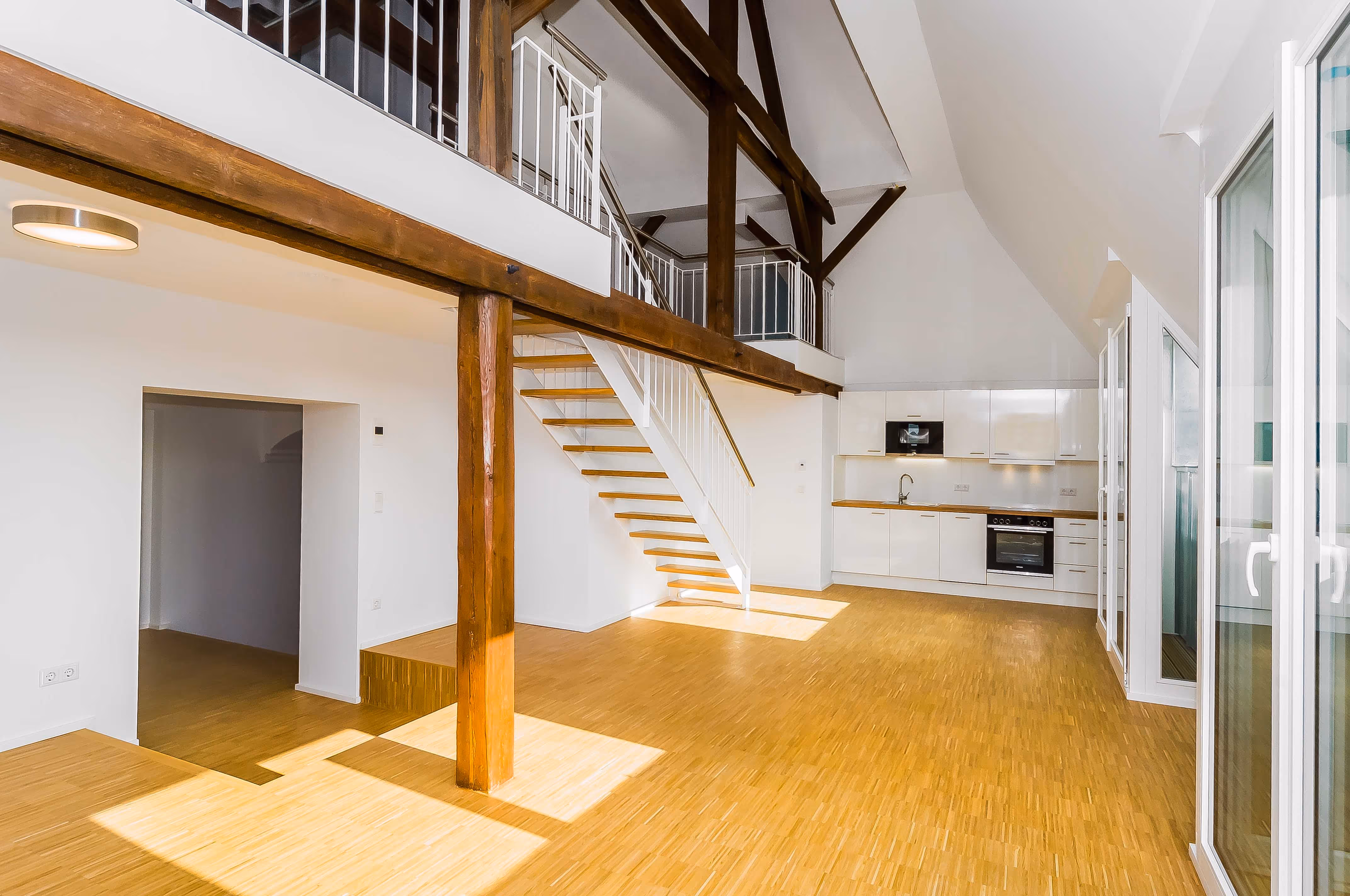 Helle Maisonette-Wohnung mit offener Galerie, moderner Einbauküche und sichtbaren Holzbalken im denkmalgeschützten Kloster „Guter Hirte“ in Aachen – einzigartiger Mix aus historischem Charme und zeitgemäßem Wohnen.