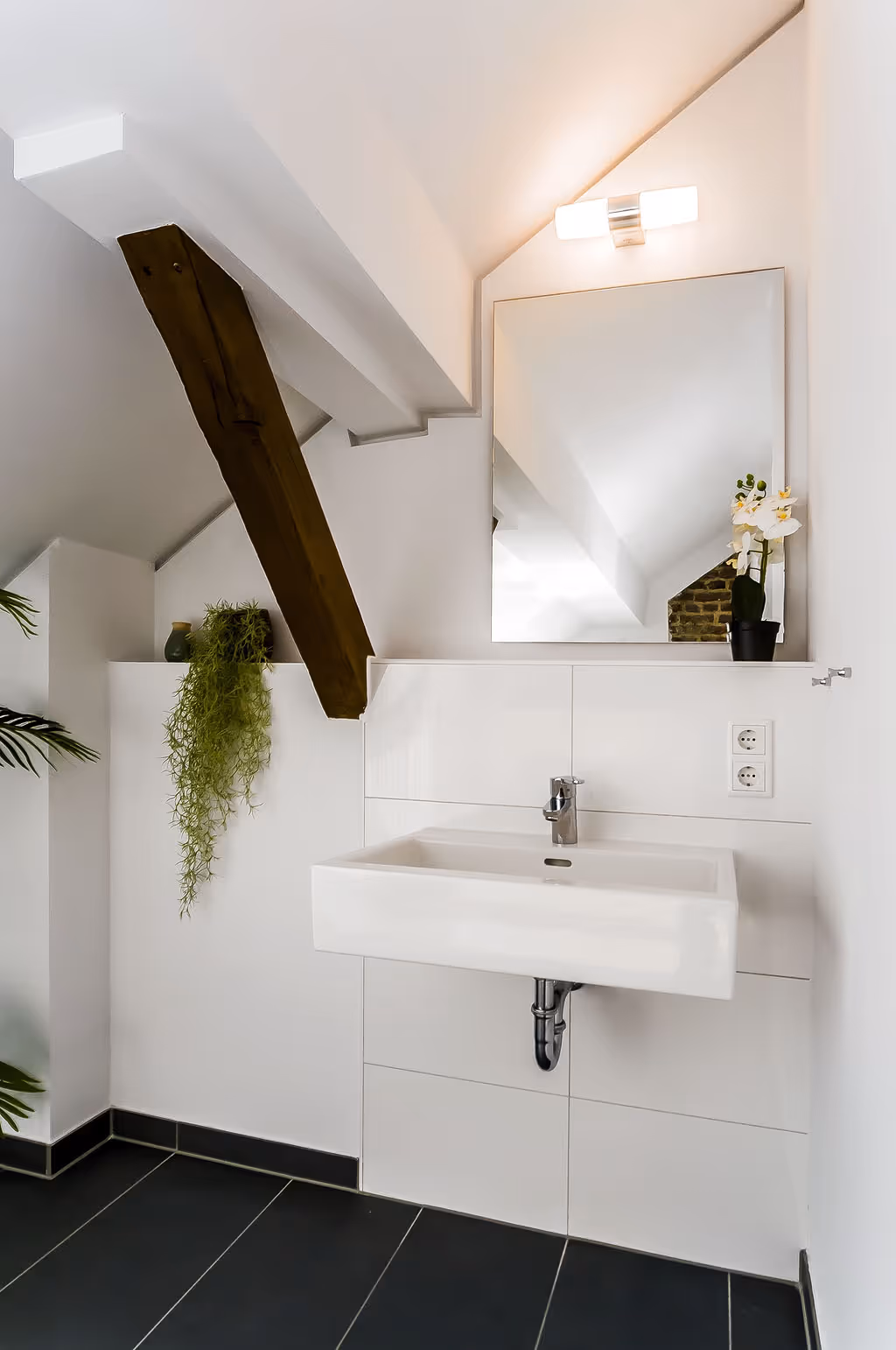 Modernes Badezimmer mit Waschtisch und Spiegel in der Maisonette im Kloster Guter Hirte Aachen.