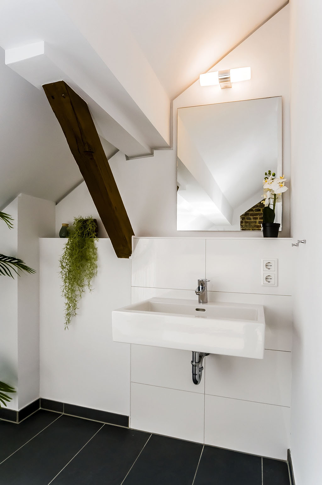 Modernes Badezimmer mit Waschtisch und Spiegel in der Maisonette im Kloster Guter Hirte Aachen.