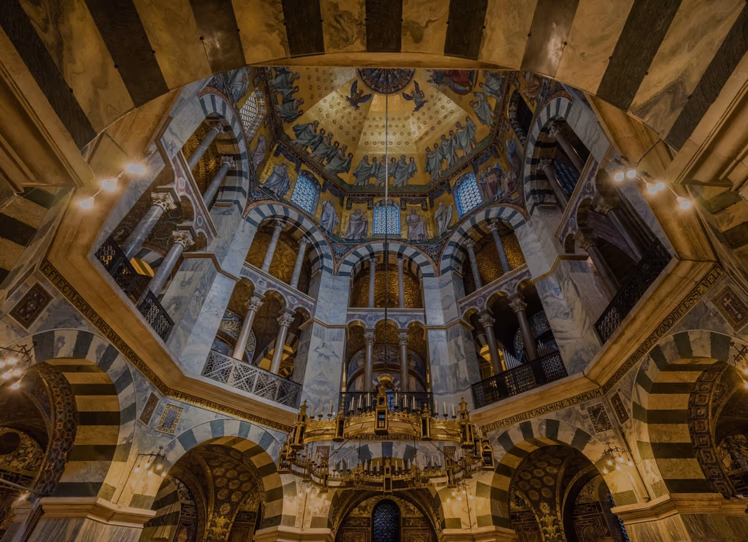 Großes, modernes Gebäude mit großen Fenstern und gepflegtem Garten mit Büschen und Sitzbereichen davor.