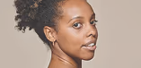 A side-profile photograph of a Black woman with an elegant updo, looking off-camera.