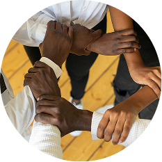 A circular image looking down at the hands of black people, joined together in a circle.