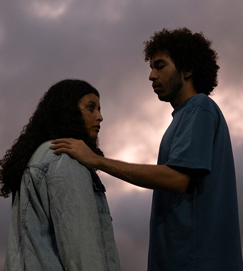 A man comforts a distressed woman by placing his hand on her shoulder.