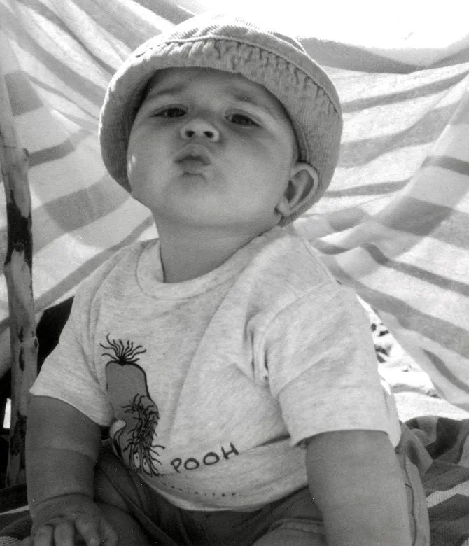 Cute kid on the beach looking into the camera