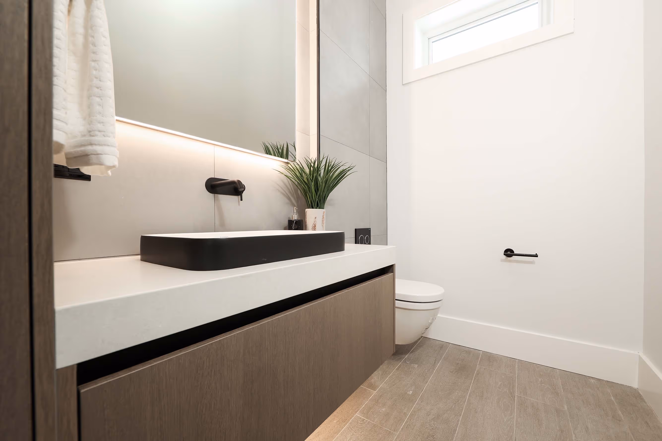 modern powder room with walnut cabinets, black plumbing fixtures and accessories