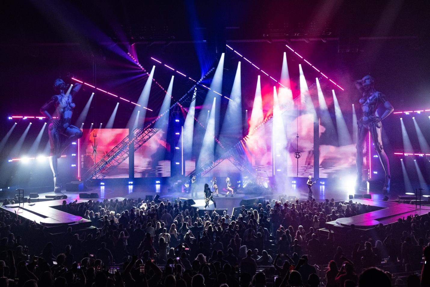 A group of people on a stage with lights and a crowd of peopleAI-generated content may be incorrect.