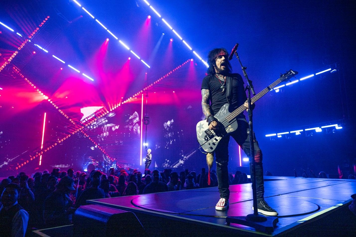 A person playing a guitar on a stageAI-generated content may be incorrect.