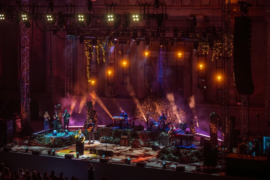 A band on stage with lights and a stage with a group of peopleAI-generated content may be incorrect.