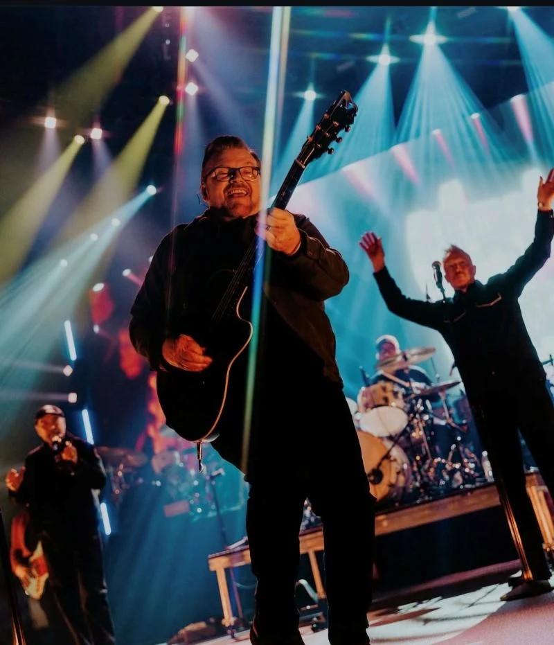 A person plays guitar on stage with a band behind them at Winter Jam 2025.