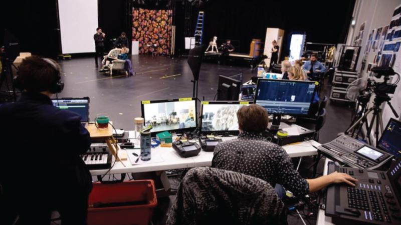 Technical artists working and watching rehearsal