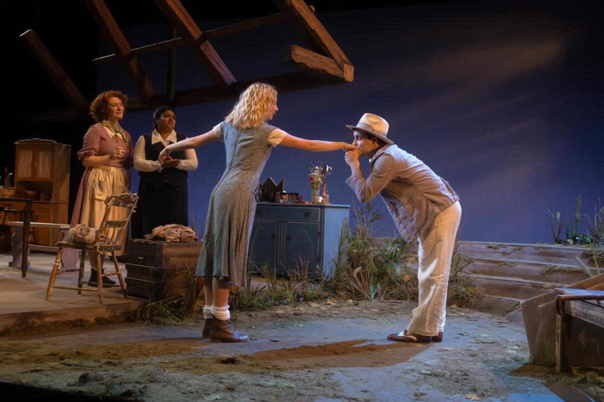 production shot of Dancing at Lughnasa. 4 people onstage with one kissing the hand of another.