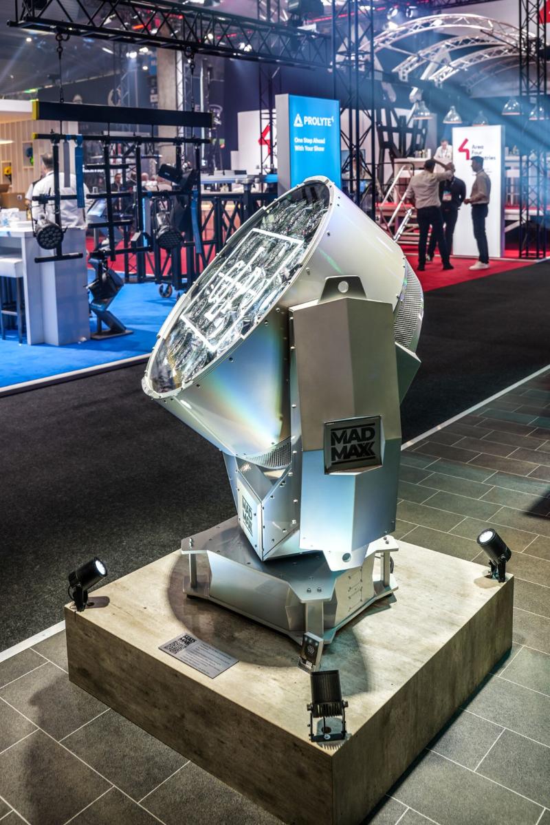 A massive silver GLP MAD MAXX light displayed on a wooden stand with GLP on the face of the light.