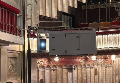 An enclosed Panasonic projector demonstrates careful installation by the team.