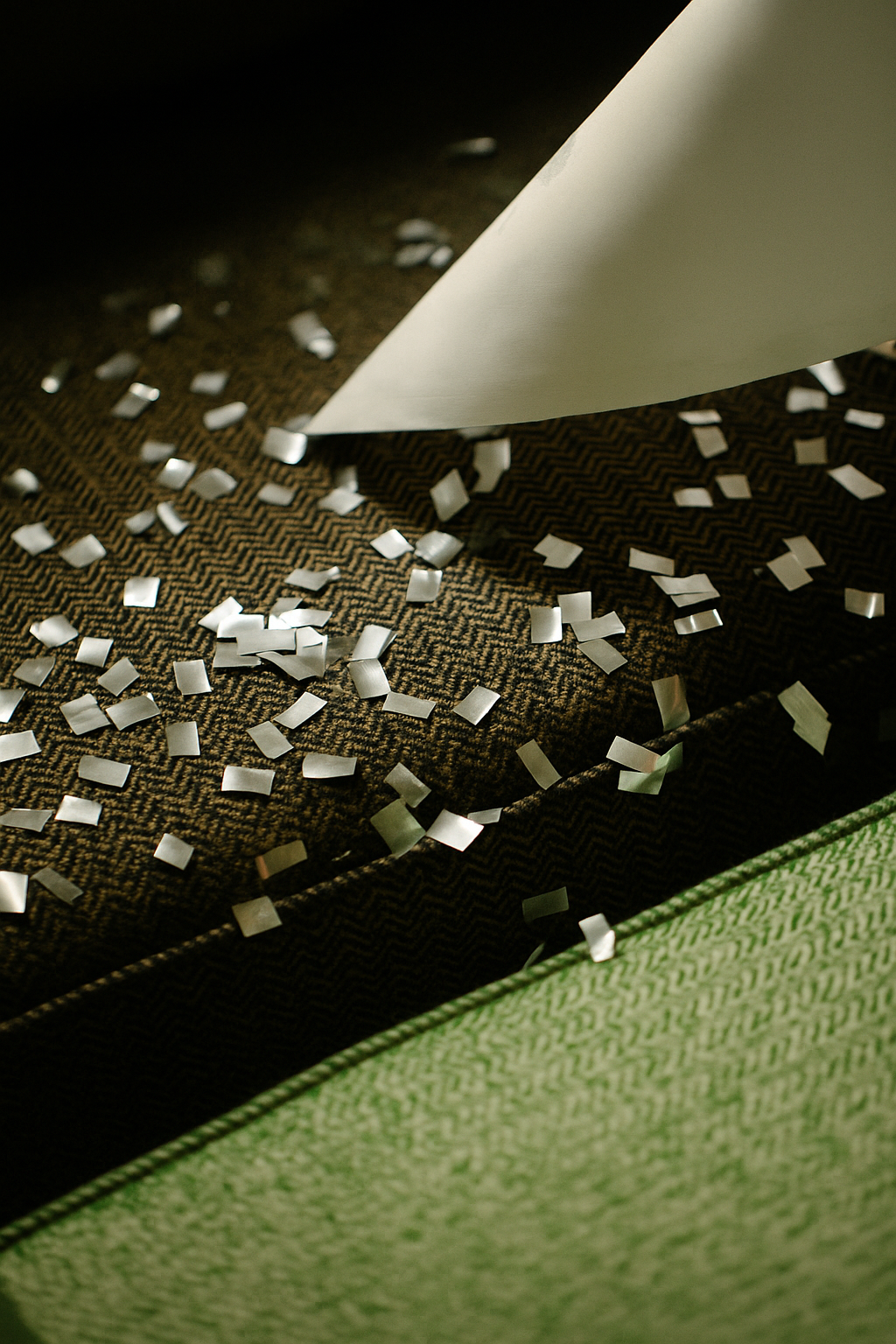 Eine Sofaecke mit silber Konfetti darauf verteilt und eine Tischdecke im Anschnitt