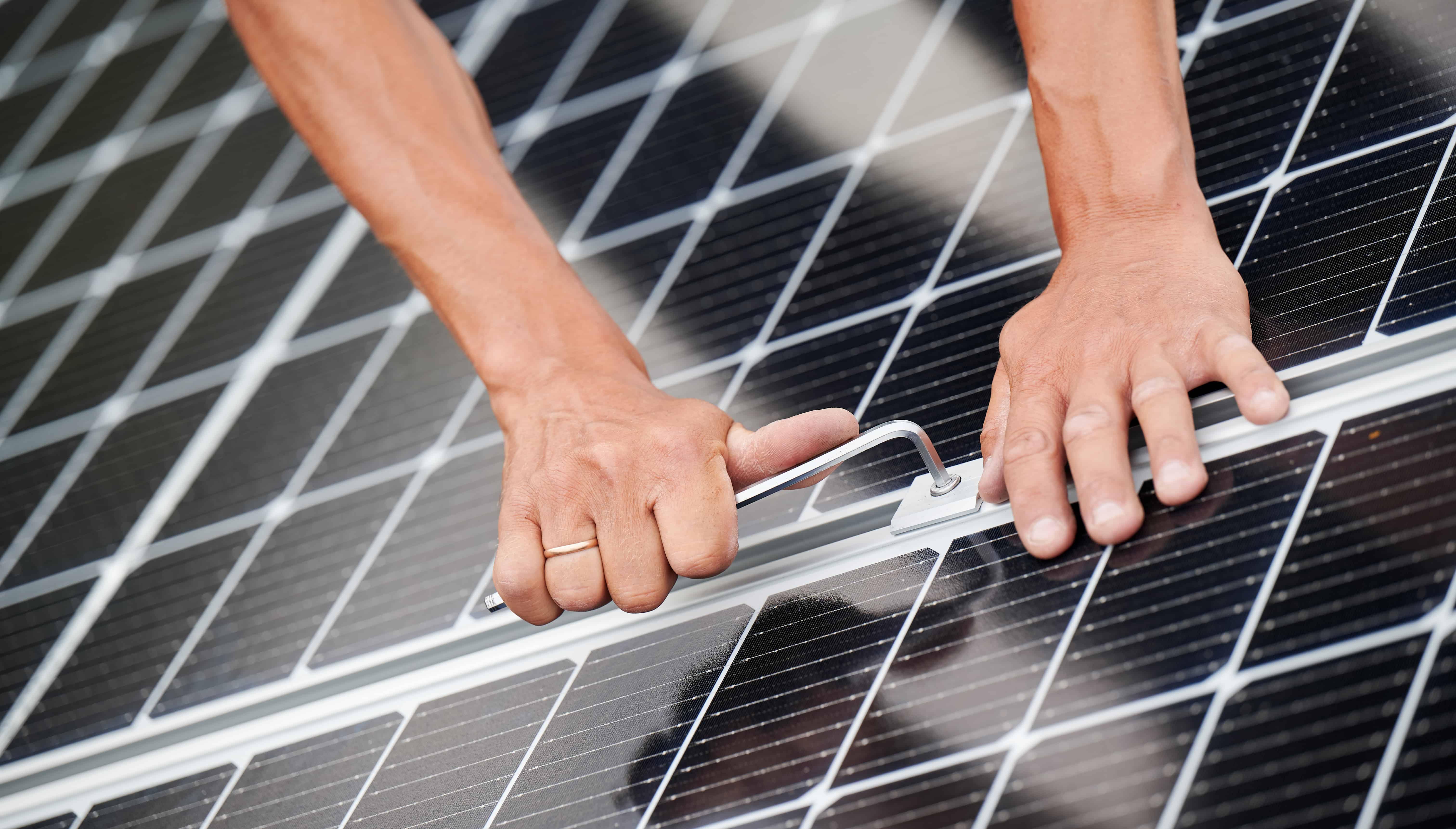 Tightening the bolt on a solar panel.