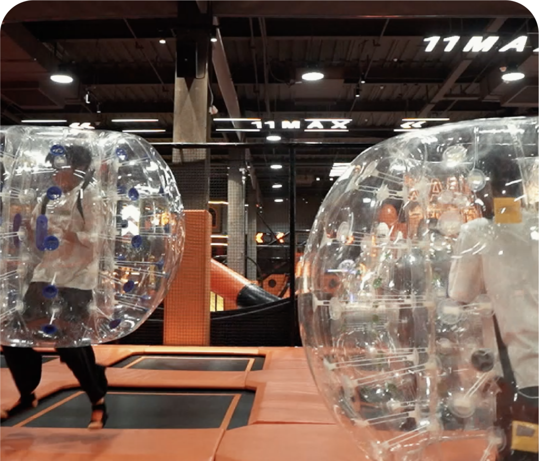 kids wrapped in plastic air bubbles jumping on trampoline