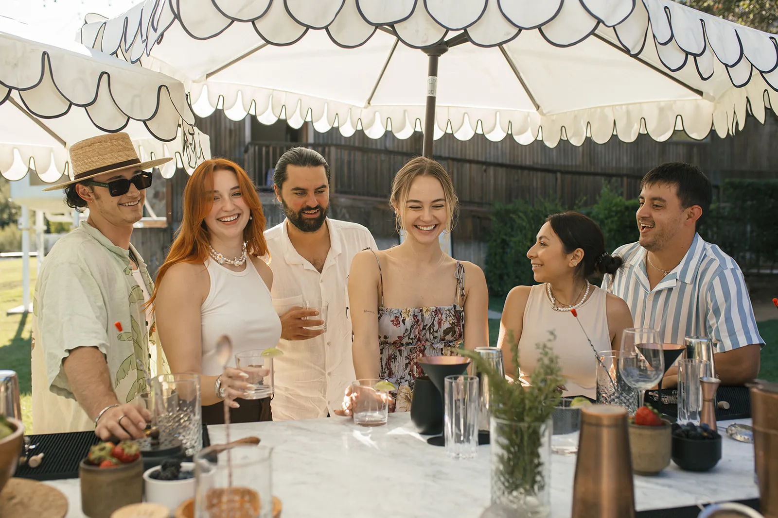 Guests enjoying cocktails and socializing at an outdoor bar at Calamigos Ranch Resort & Spa, showcasing a vibrant group experience in Malibu.