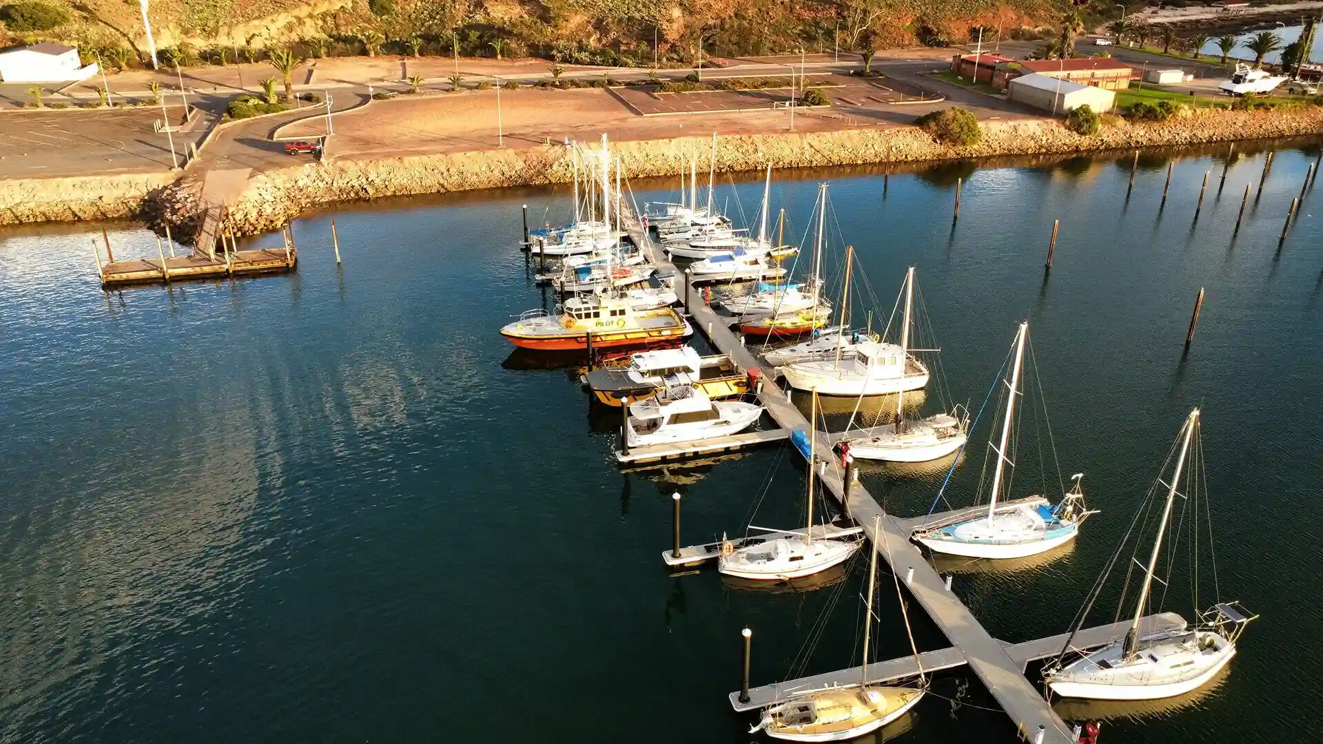 A row of boats docked at Whyalla Marina in South Australia. Some are brand new, some are well used, and all are seaworthy and ready for sale.
