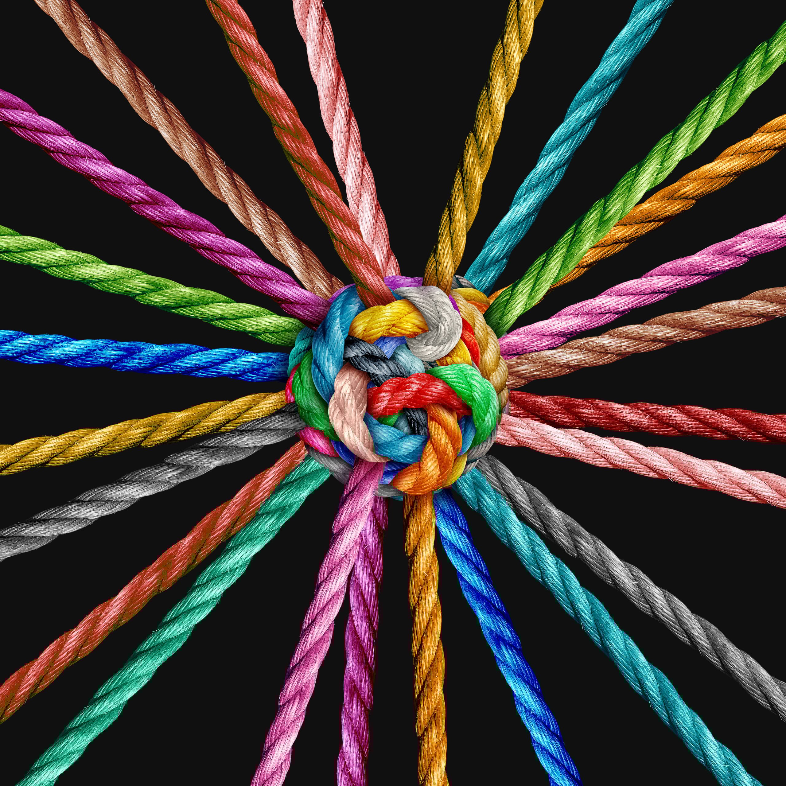Mehrere farbige Seile, die zu einem dicken Knoten in der Mitte verbunden sind und sich sternförmig nach außen erstrecken.
