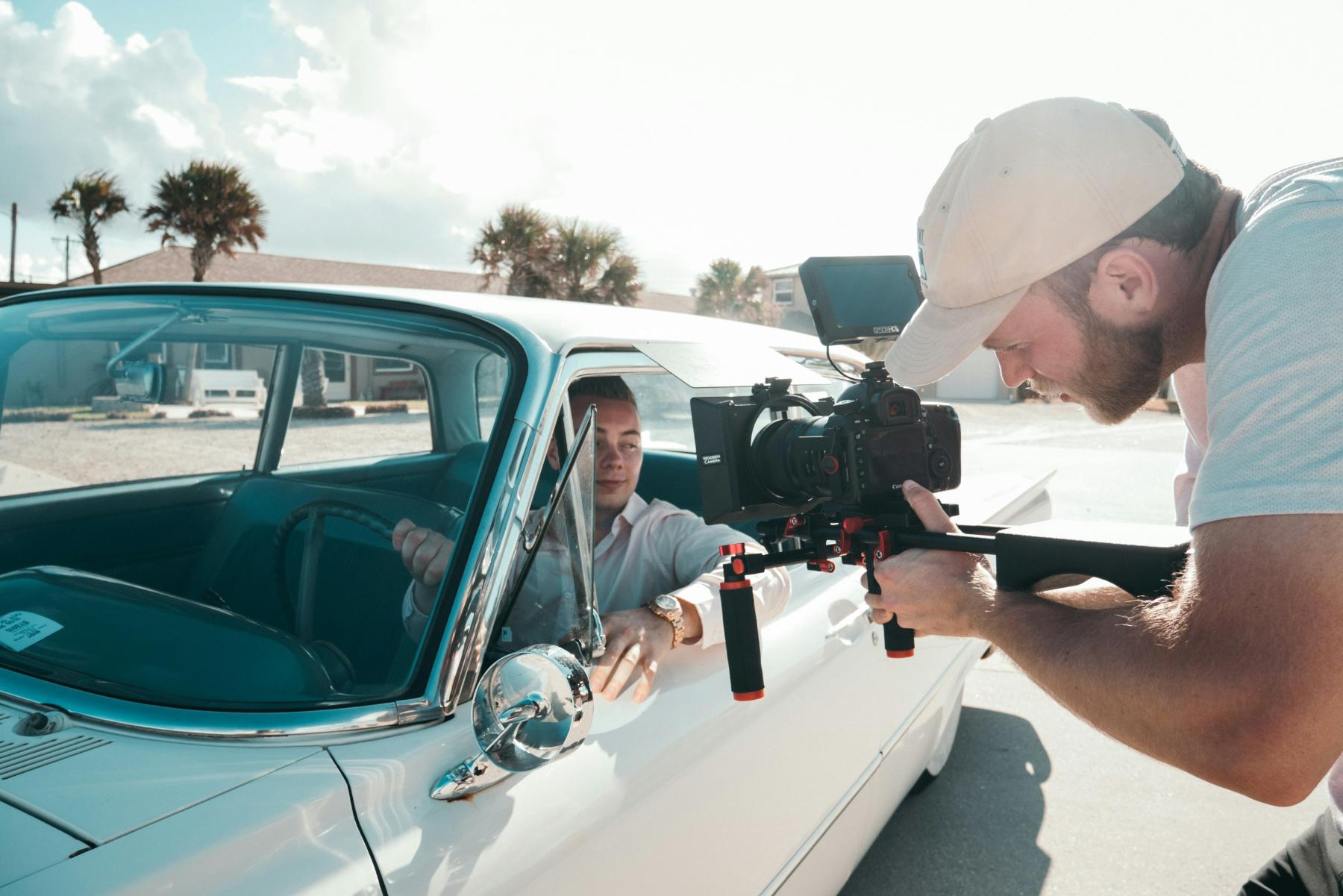 photographer pointing a camera inside a moving car
