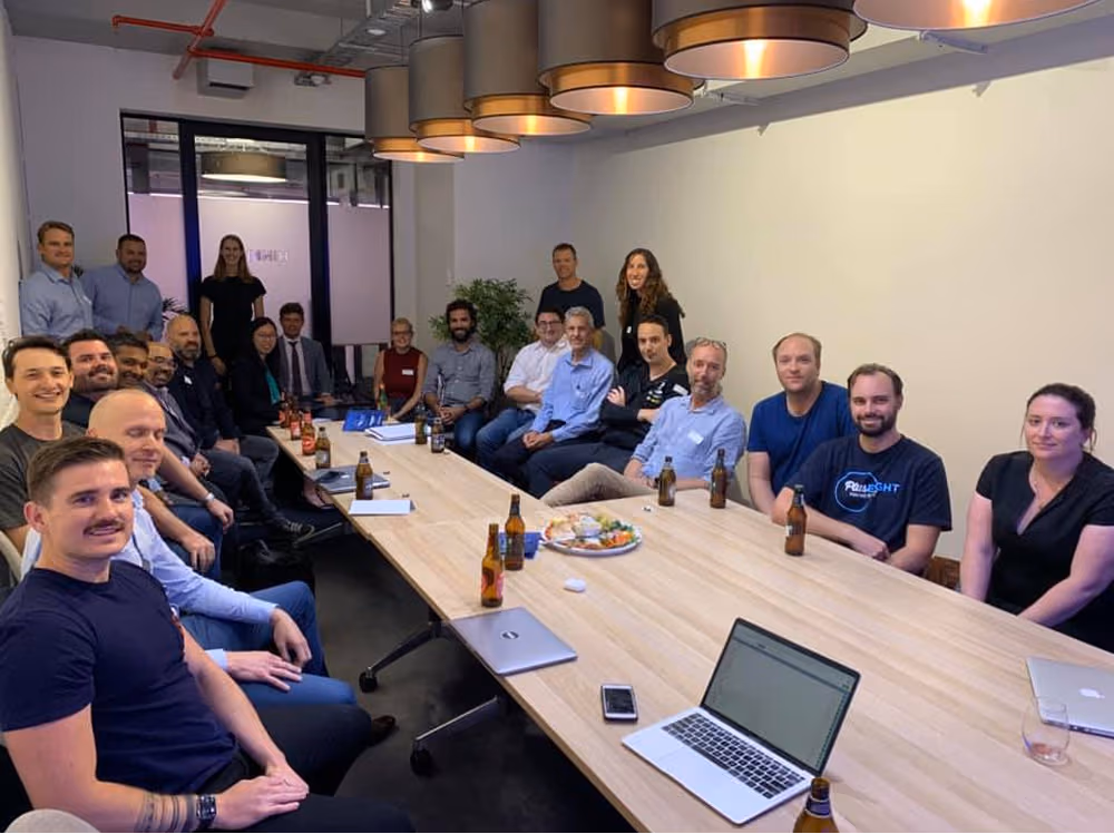 Mentors and Staff Behind the Plus Eight Accelerator at a conference table