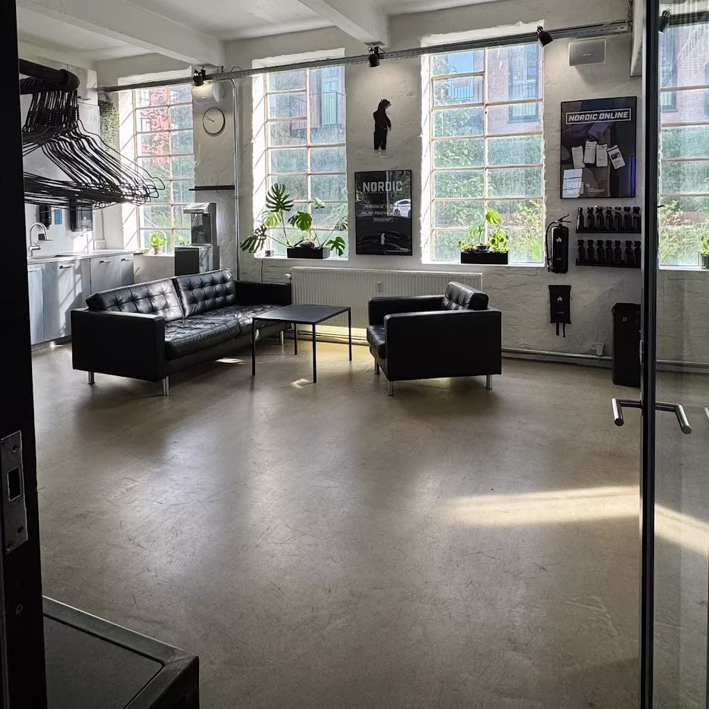 Indgang til Nordic Performance Trainings private træningscenter i København, der fører ind til et roligt og professionelt loungeområde for klienter og gæster.