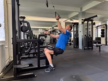 Klient i vores private motionscenter udfører kabelpulldown