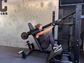 Klient i vores private motionscenter udfører pendulum squat