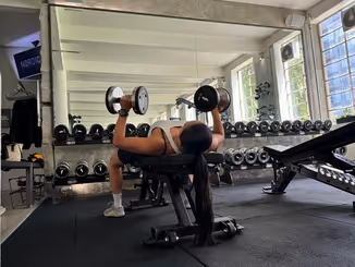 Klient i vores private motionscenter udfører håndvægts brystpresse