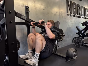 Klient i vores private motionscenter udfører pendulum squat