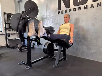 Klient i vores private motionscenter udfører benforlængelse