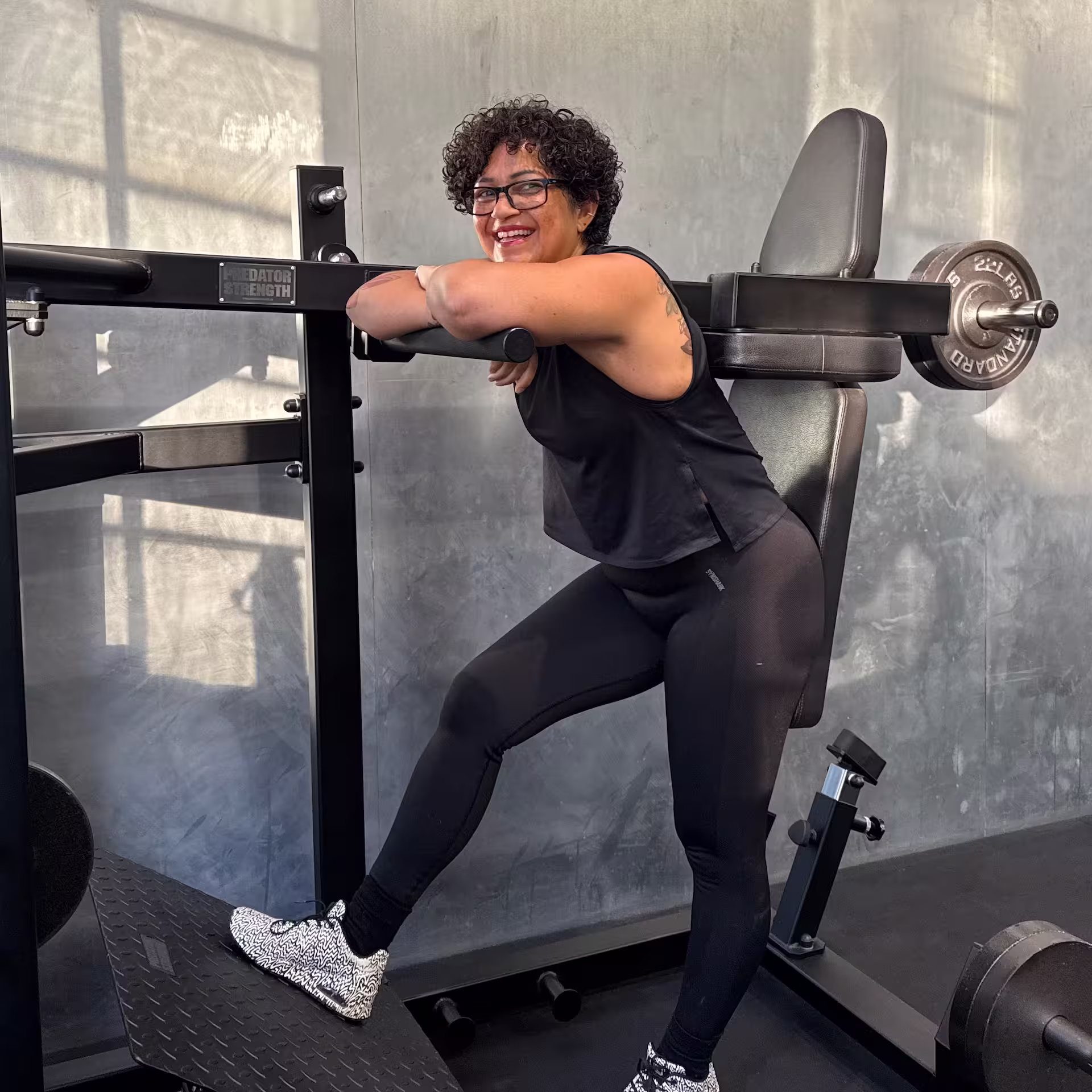 Kvindelig klient smiler og er glad fordi hendes træning fungere godt og hun kan nemt fortsætte med hendes faste træningstid med sin personlige træner i Nordic Performance Training i København.