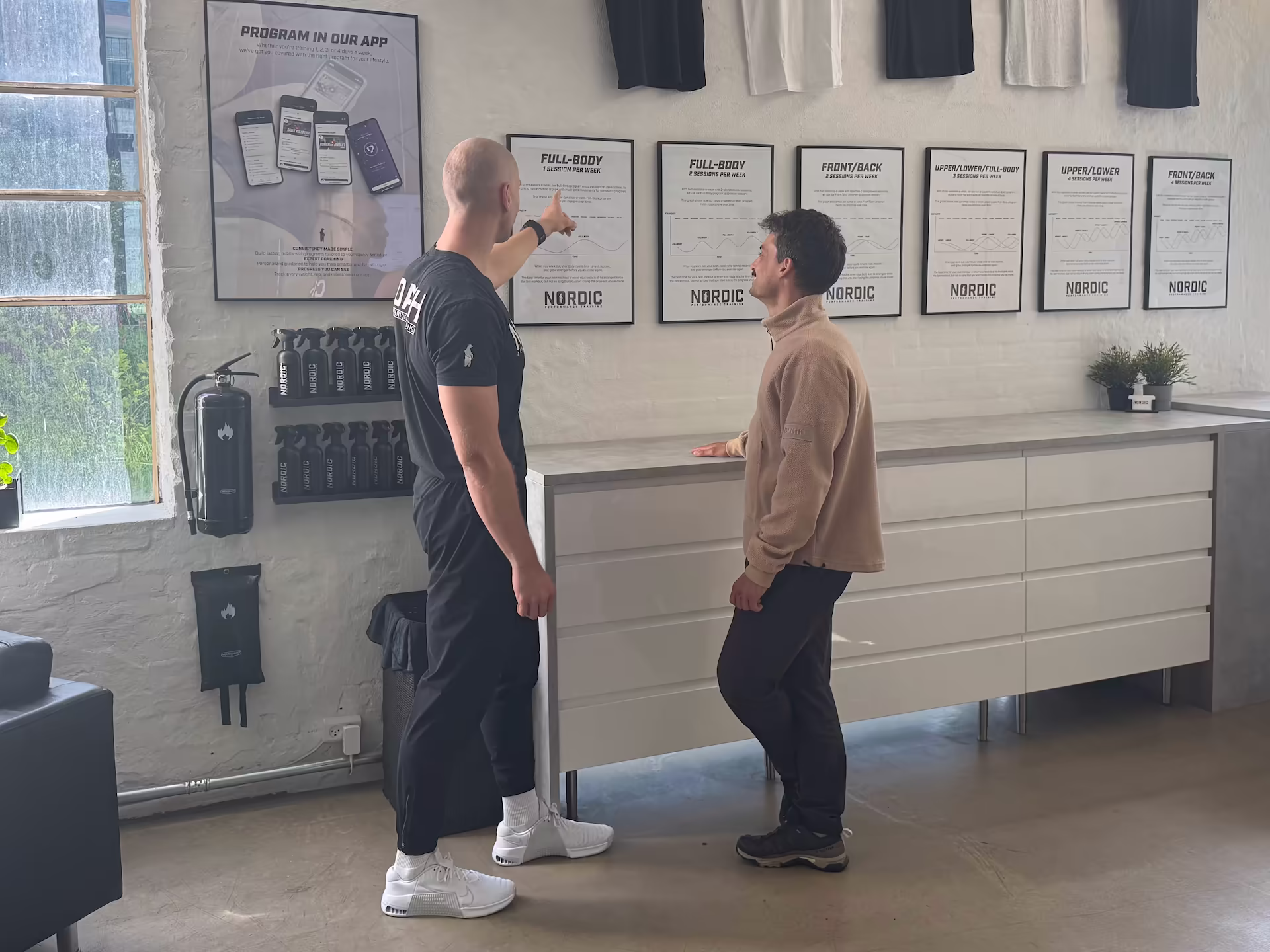 Personlig træner i Nordic Performance Trainings private træningscenter i København hjælper ny klient under gratis opstartssamtale