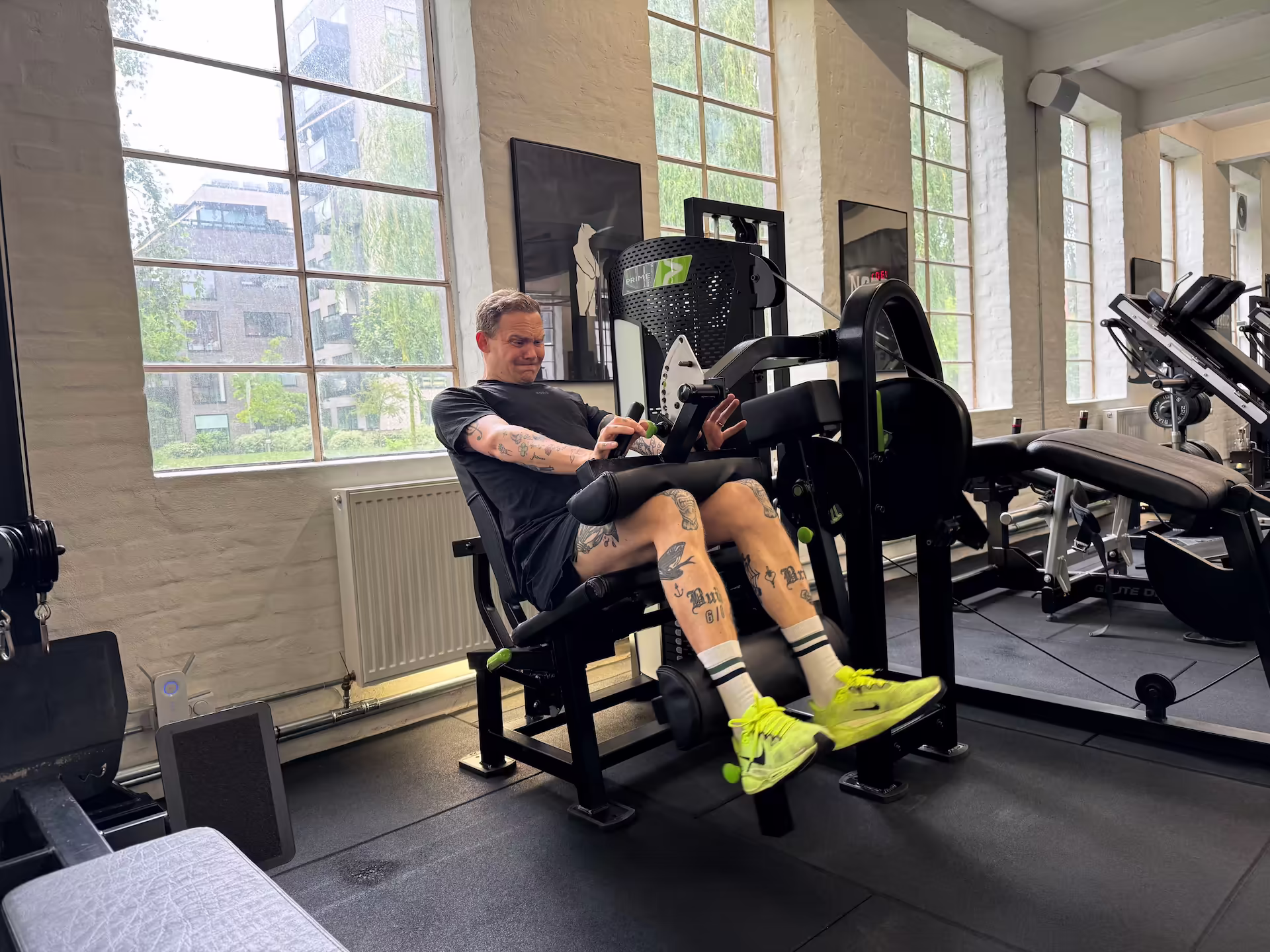 Klient udfører seated leg curls under periode med rygsmerter og viser hvordan maskinbaseret styrketræning muliggør sikker og stabil fremgang