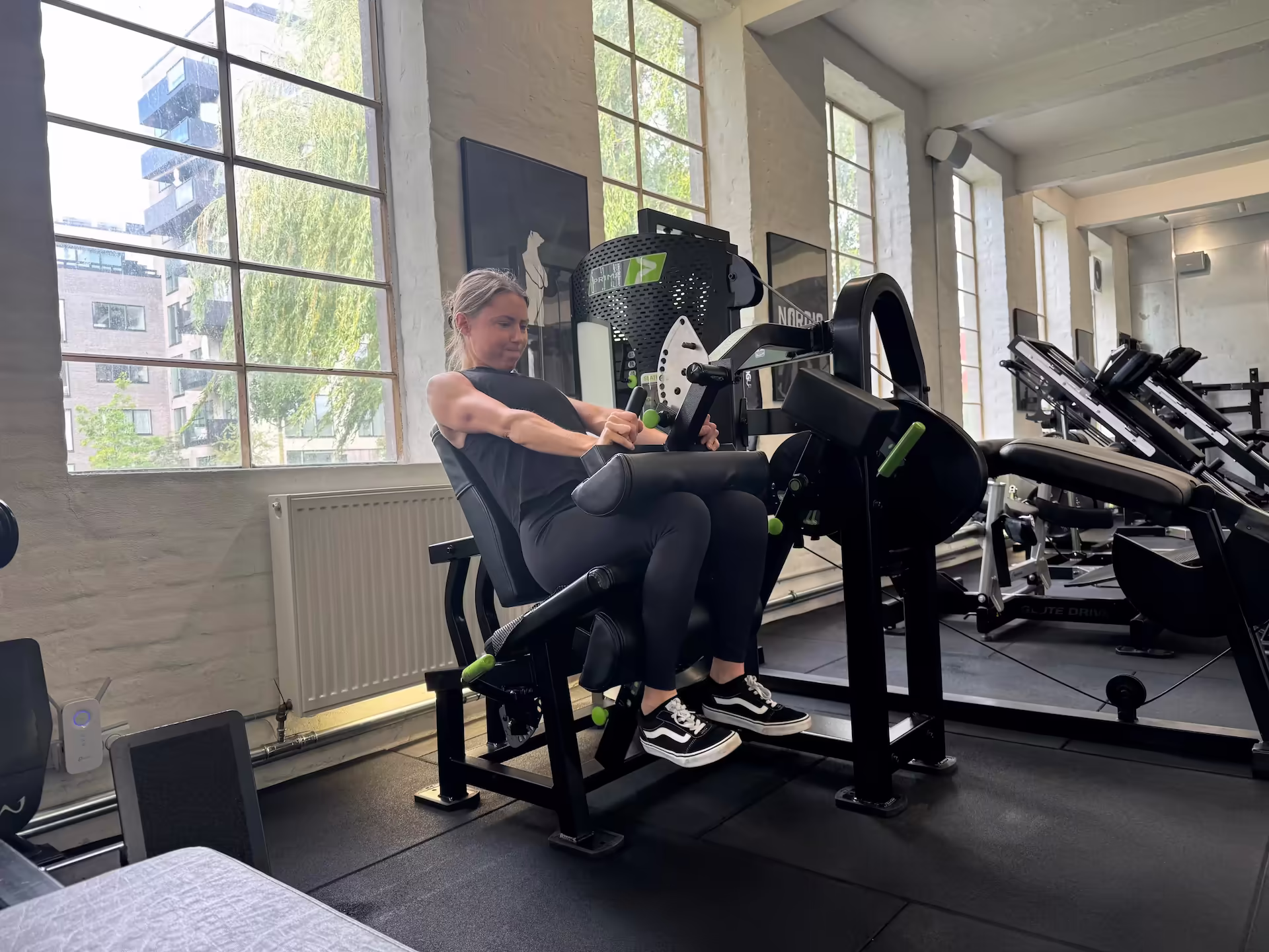 Client at Nordic Performance Training performing an intense set of seated leg curls, demonstrating glycogen depletion and muscular endurance during structured full body training.
