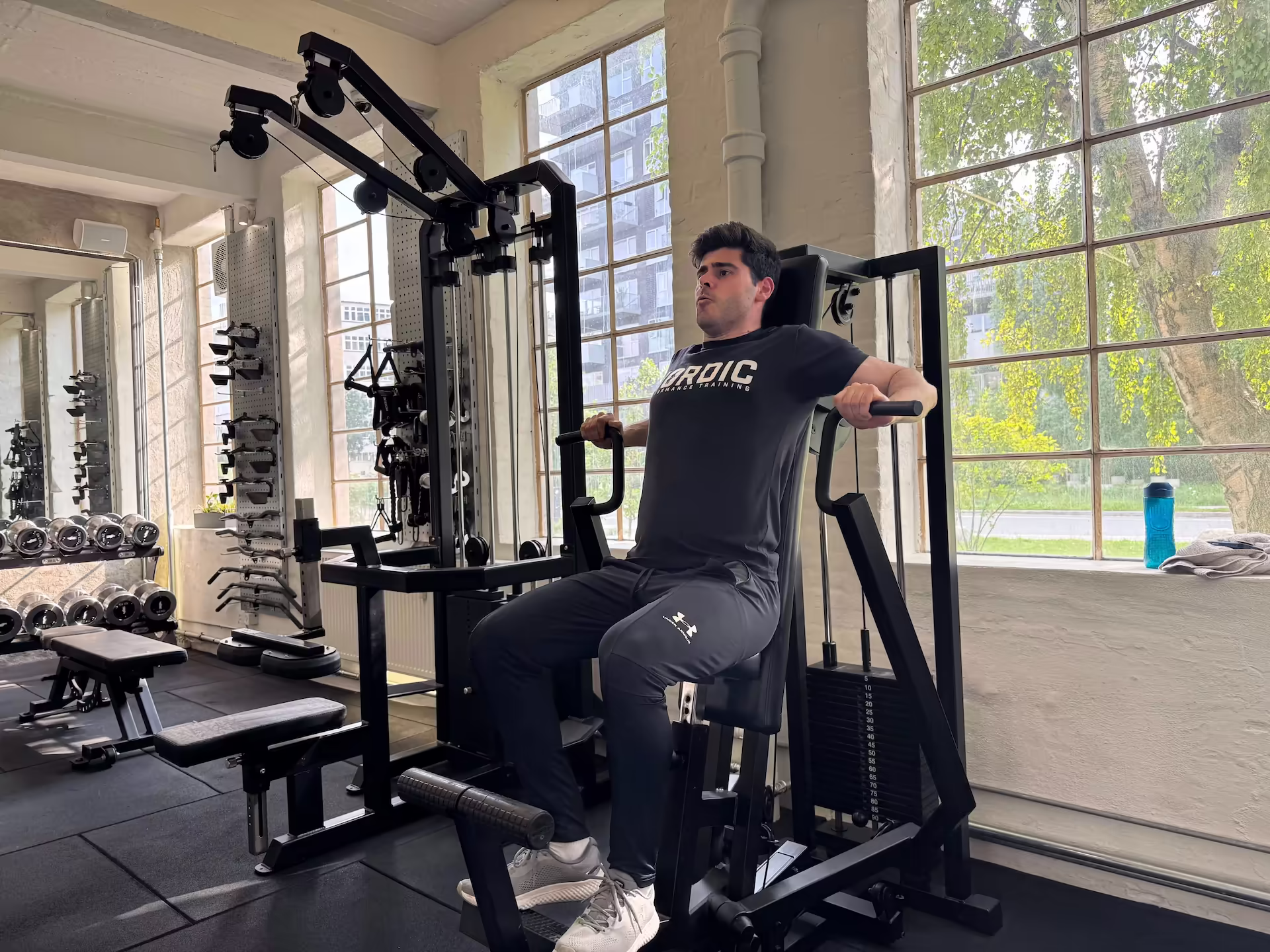 Sean, a 30-year-old consultant, performing a machine chest press at Nordic Performance Training’s private gym in Copenhagen, demonstrating strength, consistency, and structured progression through personal training.