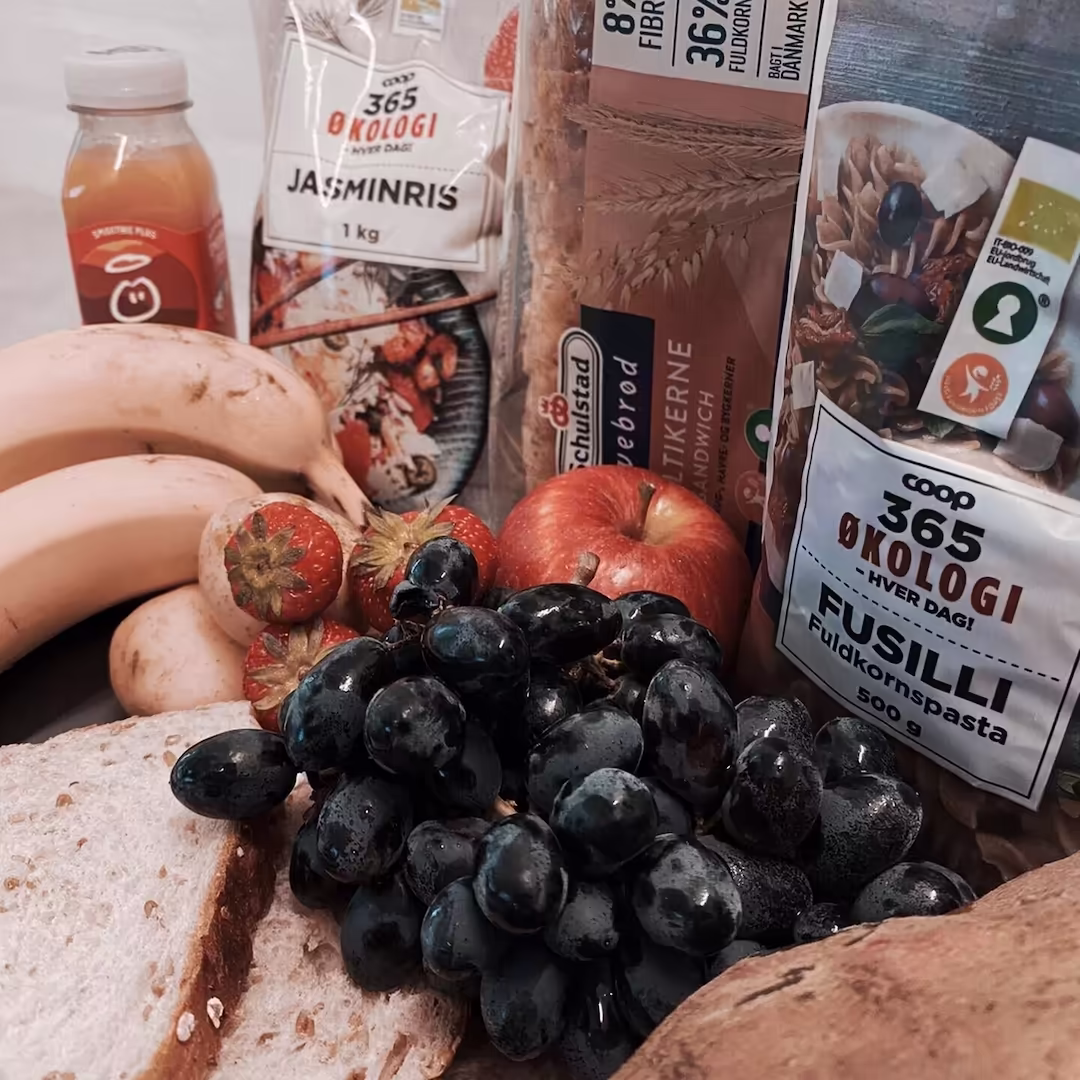 Kulhydratkilder til muskelopbygning – pasta, ris, brød, bananer og druer – essentielle energikilder til træning og restitution, anbefalet i Nordic Performance Trainings kost- og ernæringsvejledning i København.