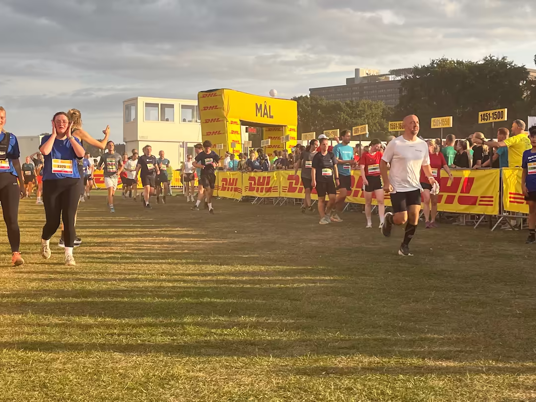 Runners crossing the finish line at DHL Relay Copenhagen – Northern Europe’s largest team relay race with over 100,000 participants, representing teamwork, motivation, and shared training goals at Nordic Performance Training.