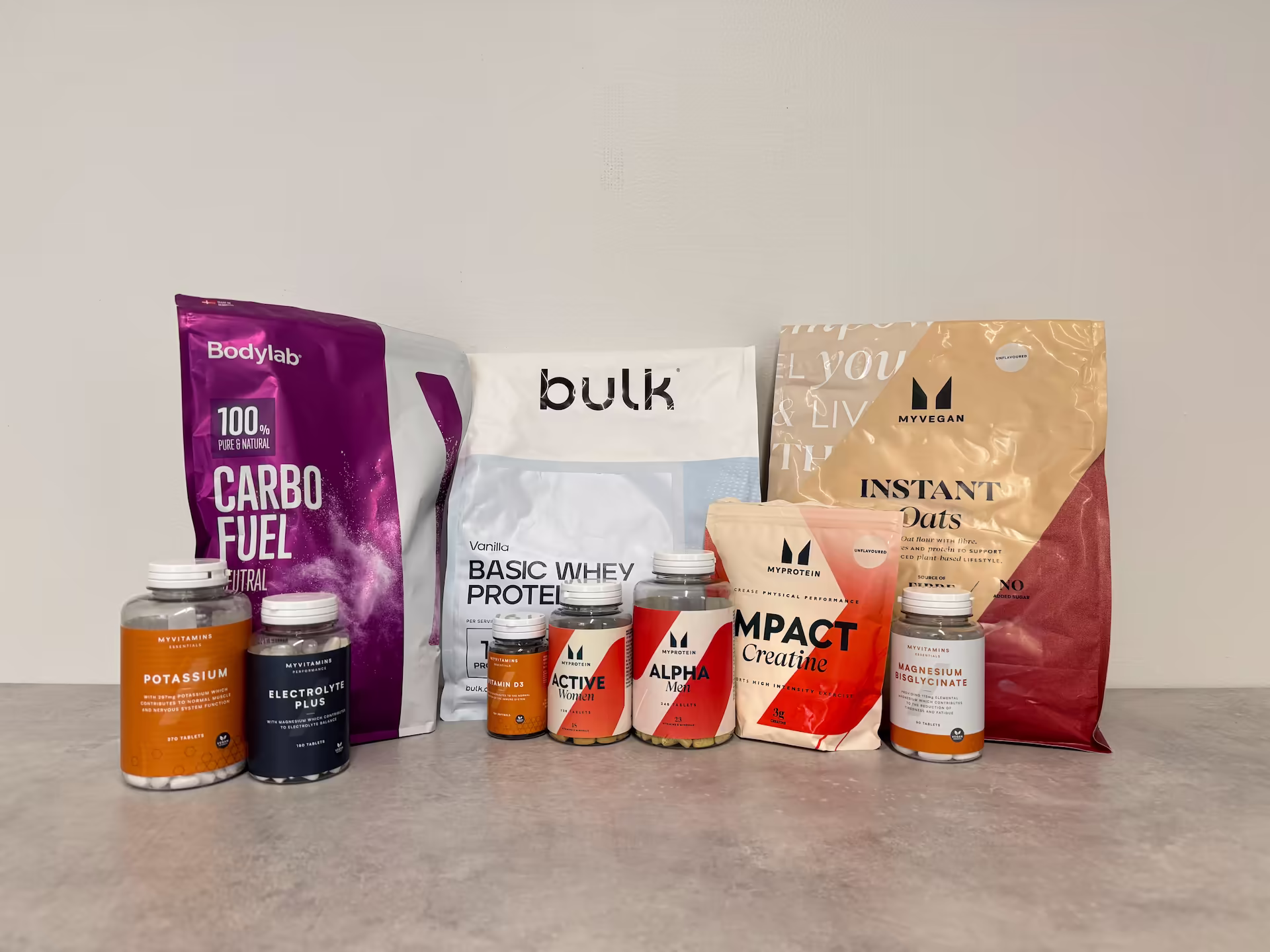 Wide selection of dietary supplements including protein powder, creatine, vitamins, minerals, and carbohydrate products from popular brands, displayed together to illustrate evidence-based supplementation for training and recovery.