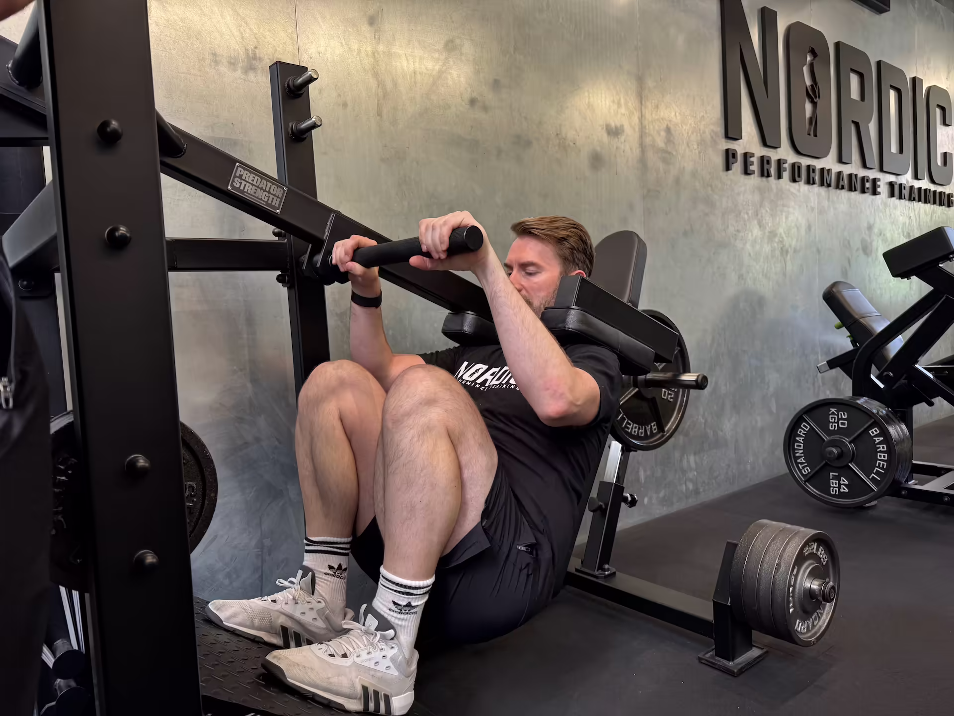 Client performing pendulum squats during a full body workout at Nordic Performance Training’s private gym in Copenhagen, demonstrating strength, control, and proper technique.