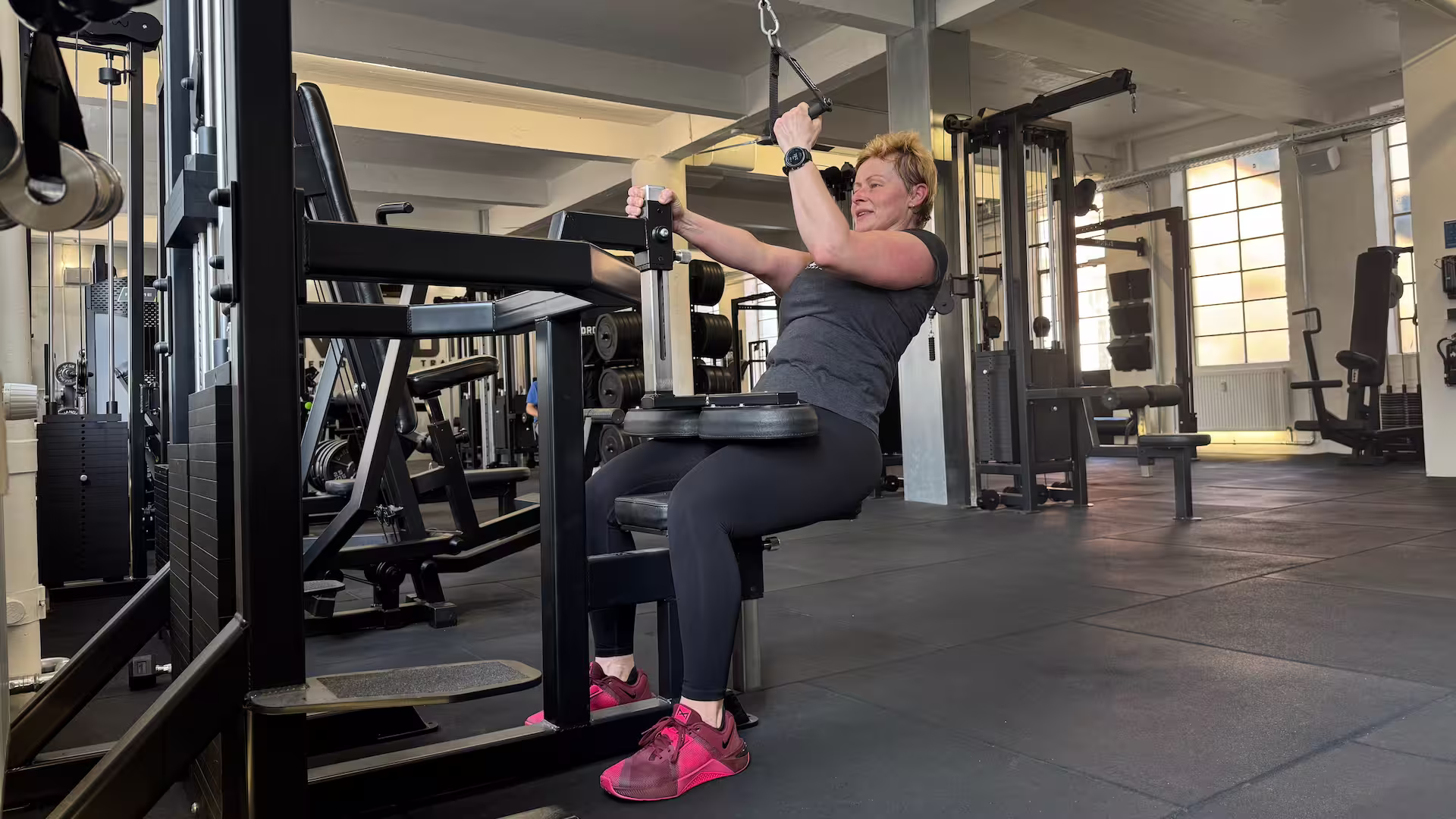 Client performs Single-arm Cable Pulldowns during her personal training session at Nordic Performance Training.
