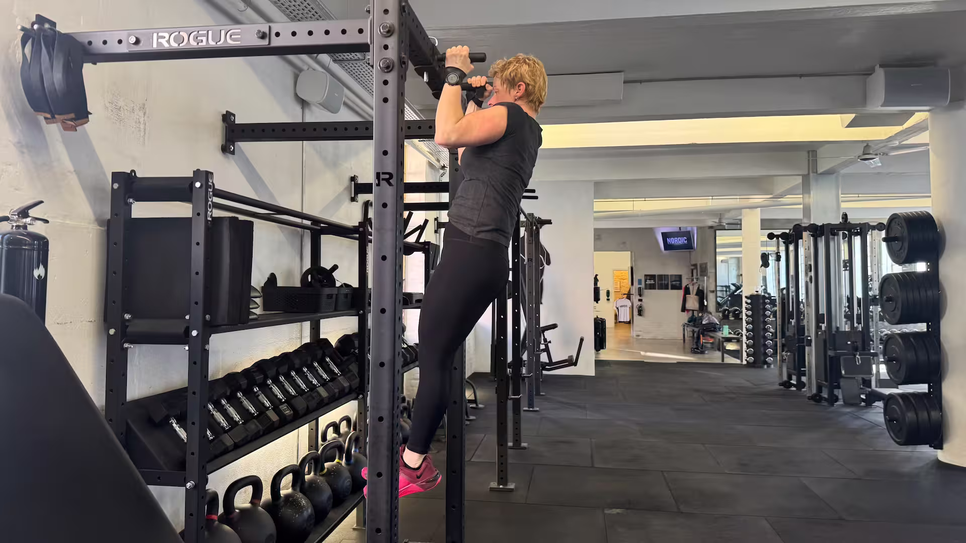 Client performs pull-up during her personal training session at Nordic Performance Training.