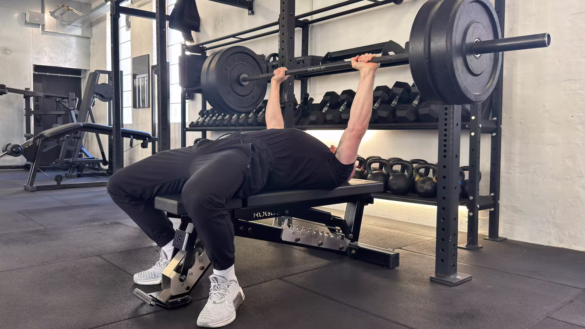 Personlige træner og autoriserede fysioterapeut Kasper Vinther demonstrerer bænk pres i Nordic Performance Training.