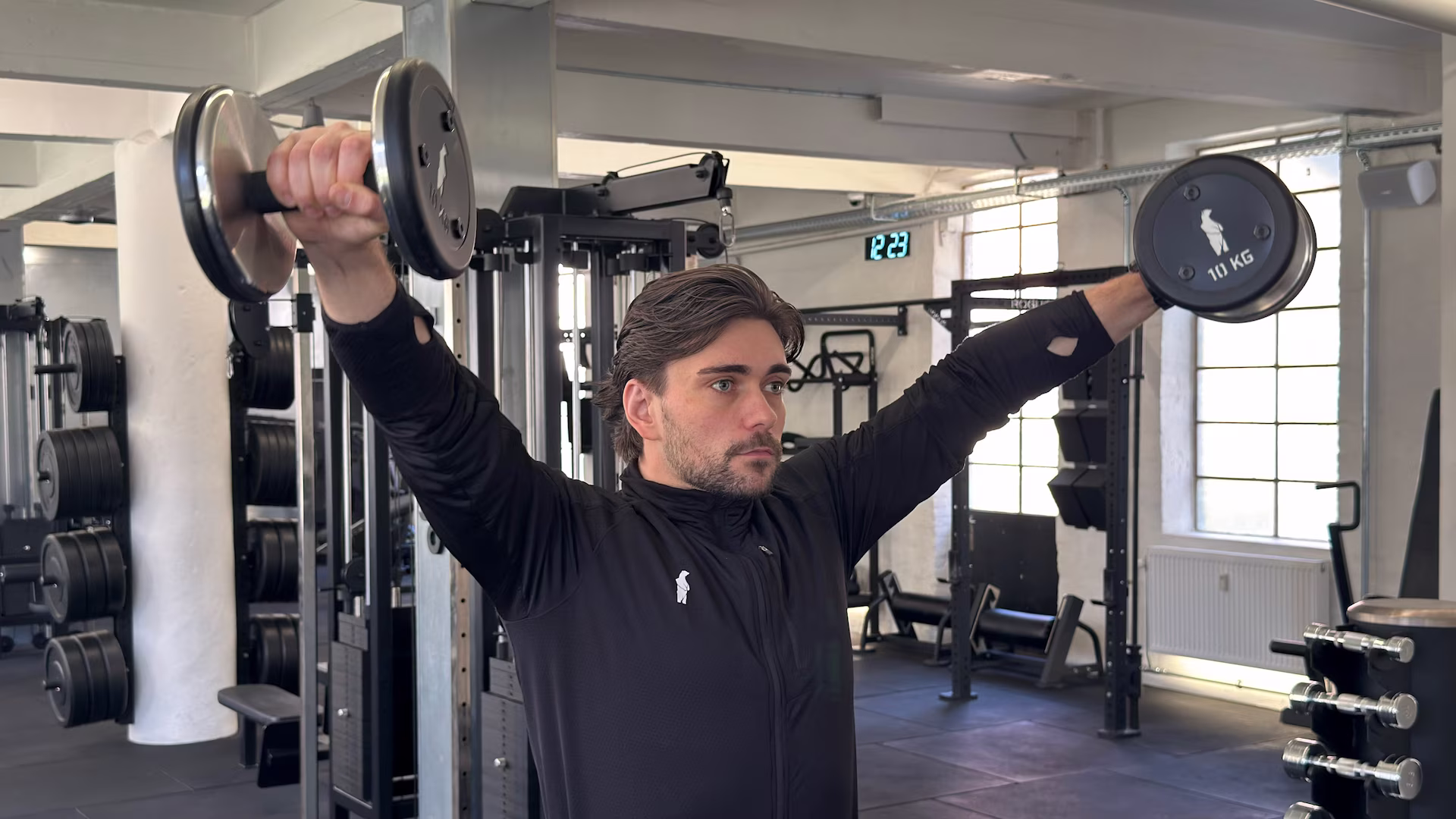 Personal trainer and licensed physiotherapist Simon Petersen demonstrates lateral raises at Nordic Performance Training in Copenhagen.