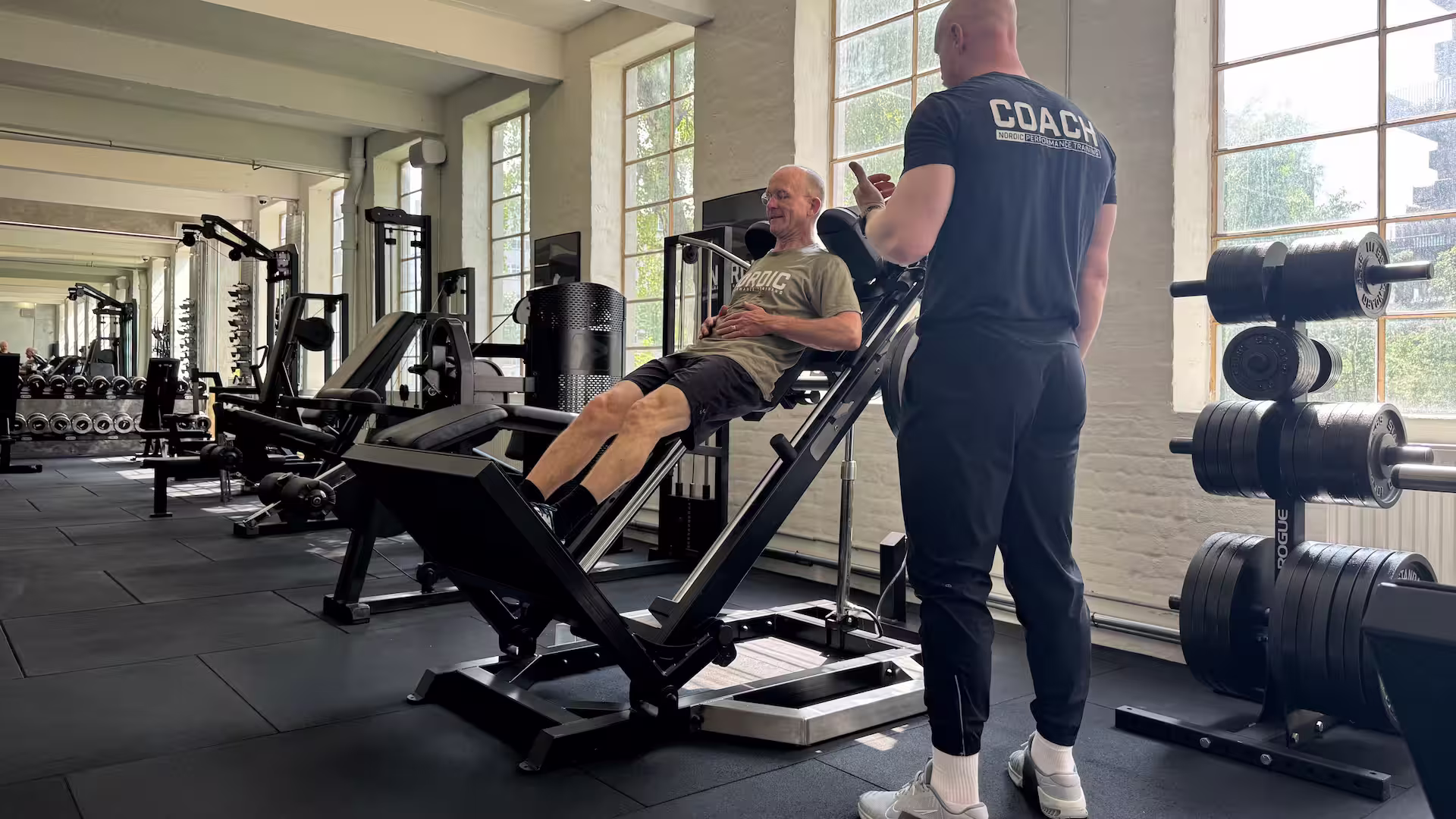 Klient udfører hack squats som del af genoptræning af forstuvet ankel i Nordic Performance Training i København.