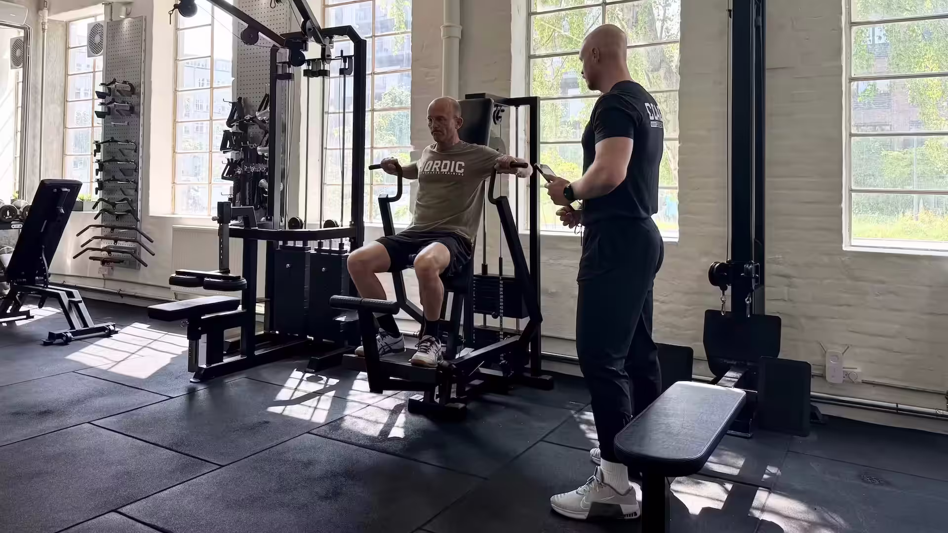 Klient med piskesmæld laver brystpres under hans personlige træningstime hos Nordic Performance Training i København.
