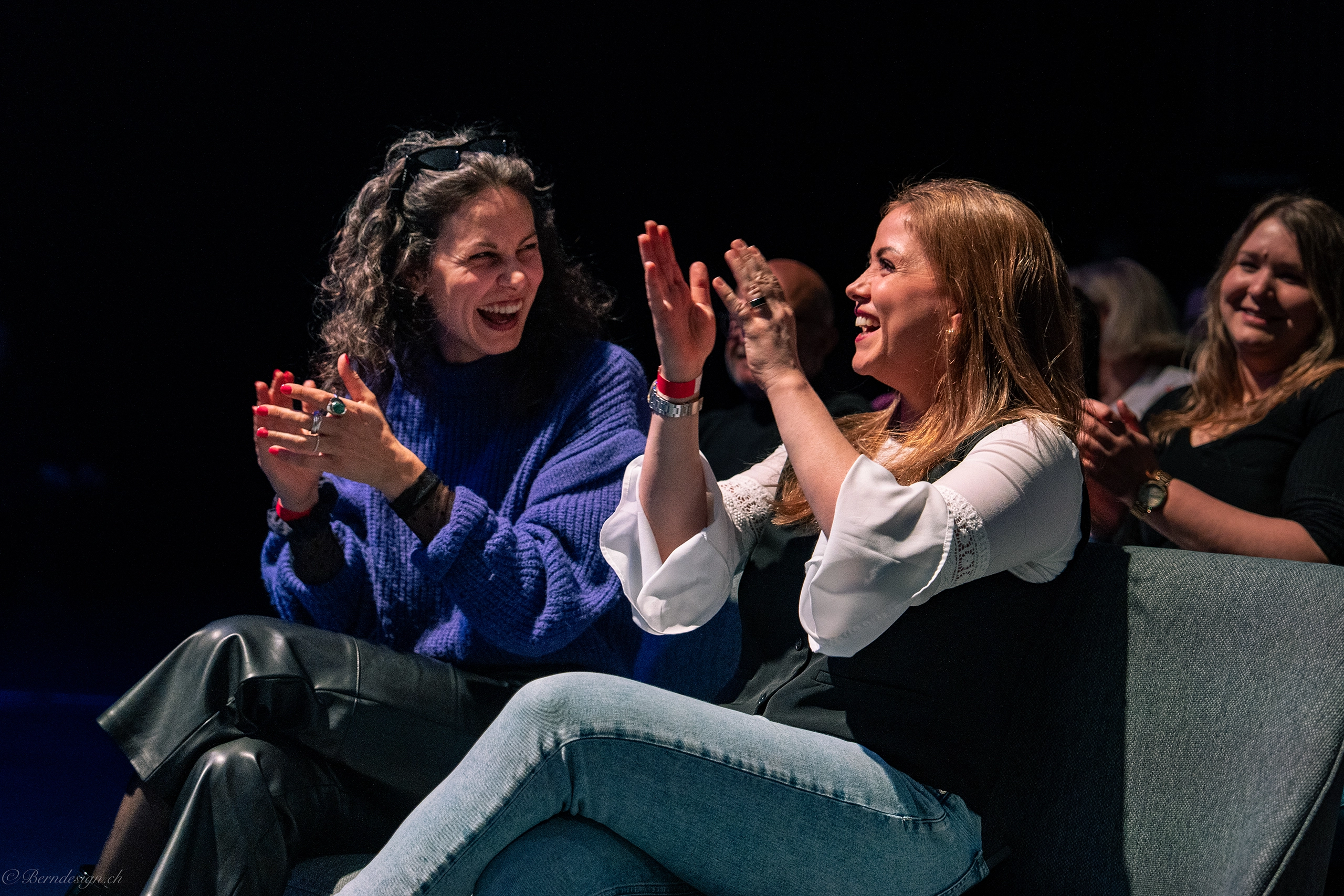 two people laughing and clapping
